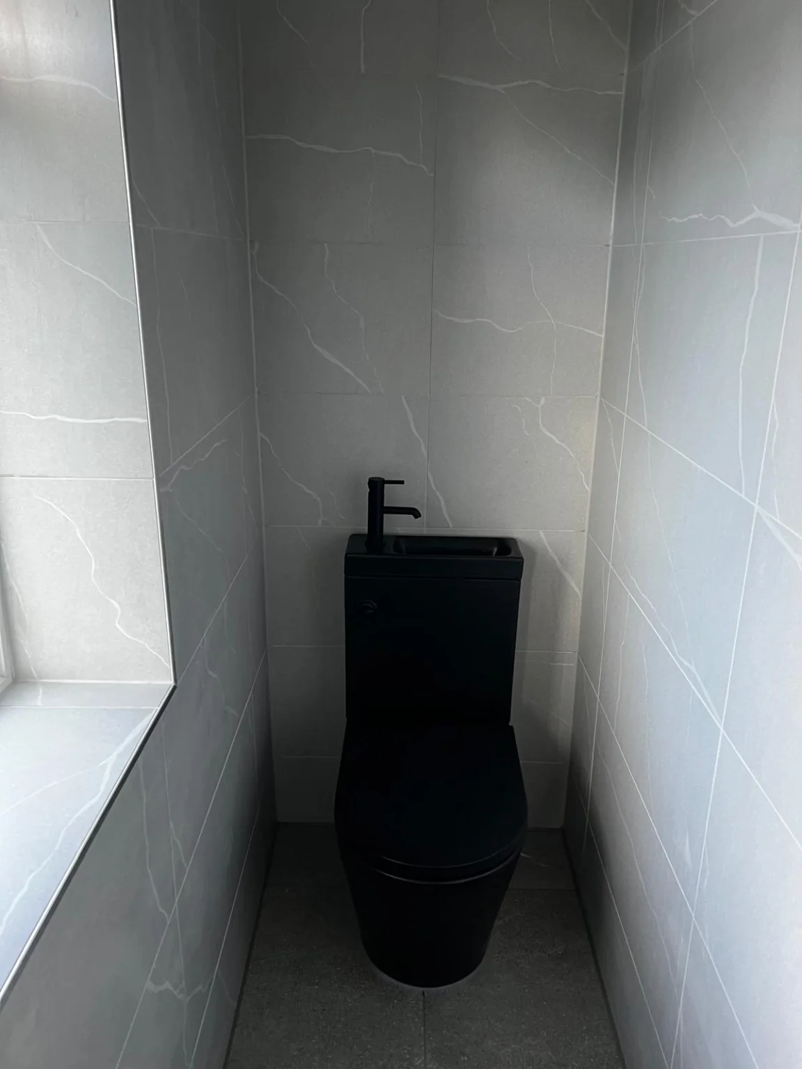Completed black toilet installation front view