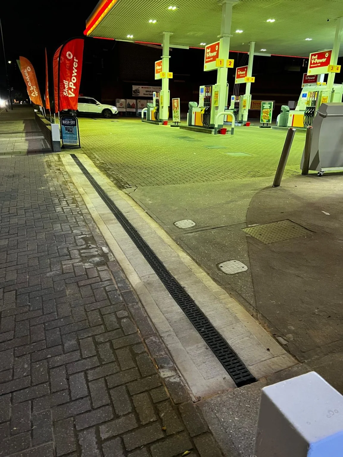 Completed linear drainage installation at a Shell petrol station forecourt