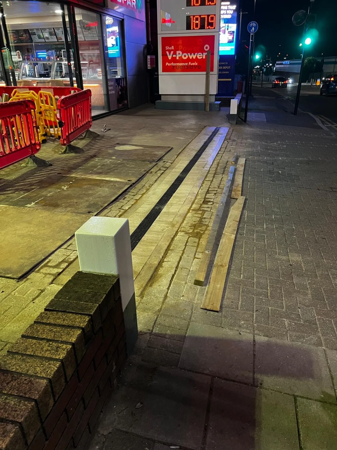 Close view of ACO-style channel drainage installed beside Shell forecourt paving