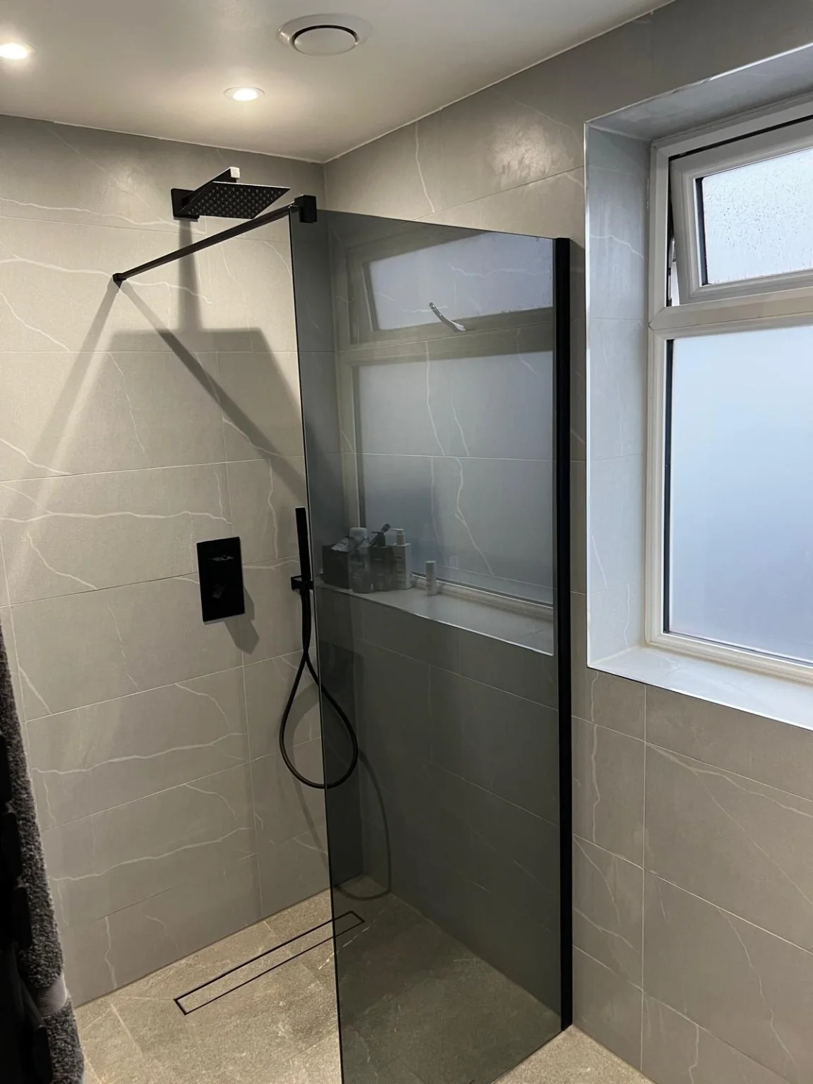 Finished shower with black framed glass screen