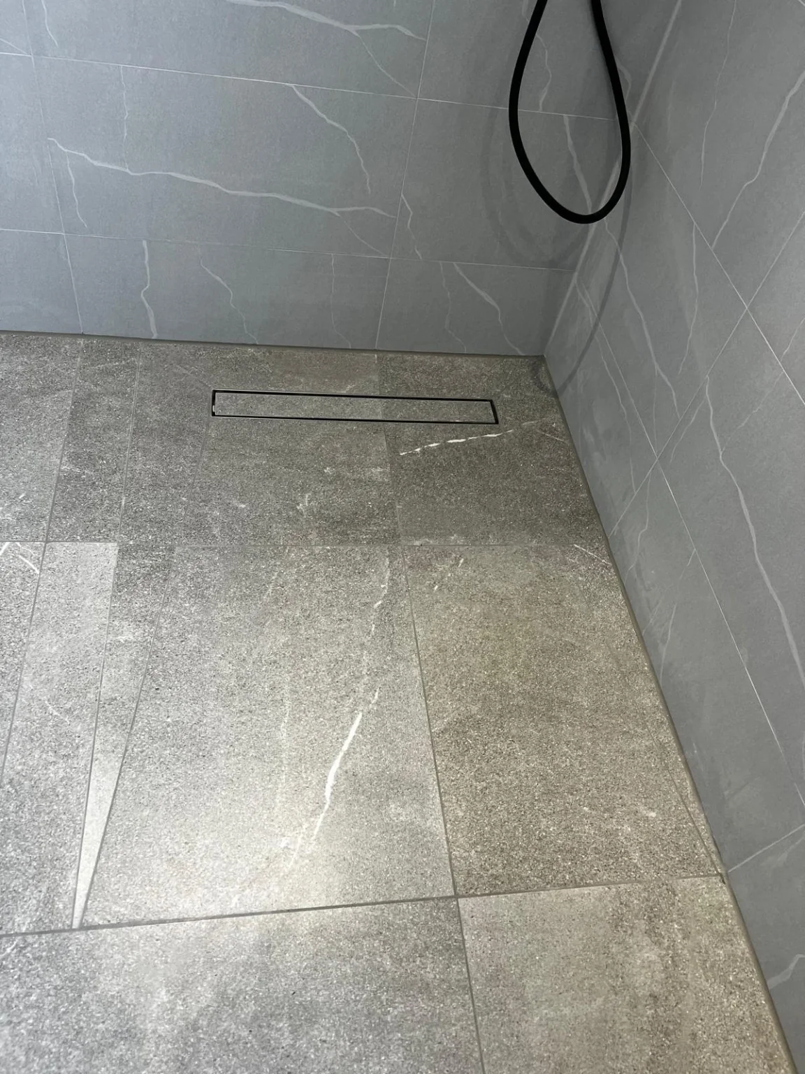 Linear floor drainage detail in finished walk-in shower